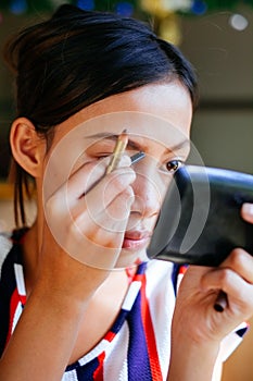 Young beautiful girl applying makeup. Girl coloring eyebrows with eyebrow liner