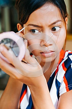 Young beautiful girl applying makeup. Girl coloring eyebrows with eyebrow liner