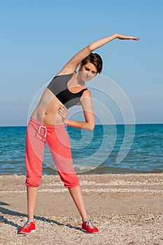 Young beautiful girl athlete playing sports on the beach
