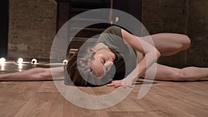 Young beautiful girl ballerina is dancing, laying on floor, stairs on background, ballet concept, movement concept