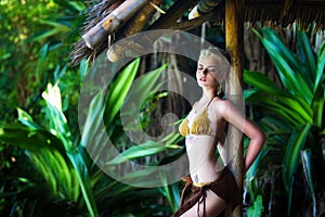 Young beautiful girl in a bamboo hut in a tropical jungle