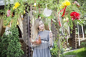 Young beautiful girl with a basket with Easter eggs on background Easter tree