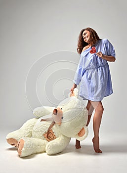 Young beautiful girl with big teddy bear soft toy happy smiling