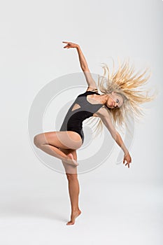 A young beautiful girl in black bodysuit posing in studio