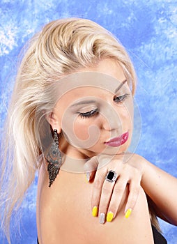 Young beautiful girl in black earrings on an abstract background