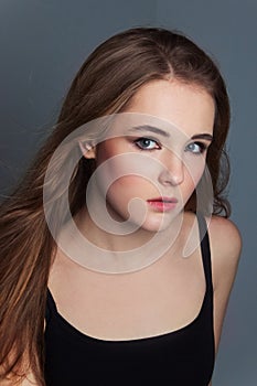 Young, beautiful girl in a black t-shirt. Professional model posing in Studio on white-gray background. Take a model test
