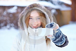 Young beautiful girl with blank visiting card. Winter.