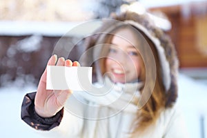 Young beautiful girl with blank visiting card. Winter.