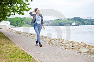 Young beautiful girl in blue jeans and a black leather jacket on