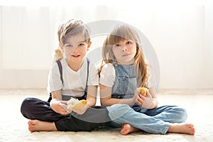 Young beautiful girl and boy, playing with little newborn chick