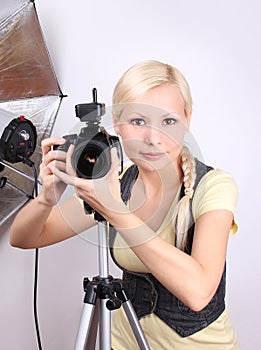 Young beautiful girl with the camera in studio