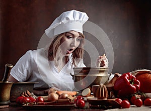 Young beautiful girl in a chef uniform with old brass pan and w