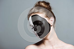 Young beautiful girl with closed eyes and creative white and black bodyart on face,
