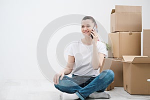 Young beautiful girl with colored hair in a white T-shirt and jeans, talking on the phone and writes messages against