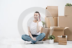 Young beautiful girl with colored hair in a white T-shirt and jeans, talking on the phone and writes messages against