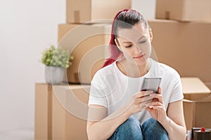 Young beautiful girl with colored hair in a white T-shirt and jeans, talking on the phone and writes messages against