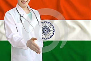 Young beautiful girl doctor with an open smile holds out his hand for greeting on the background of the national flag, concepts of