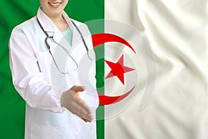 Young beautiful girl doctor with an open smile holds out his hand for greeting on the background of the national flag, concepts of