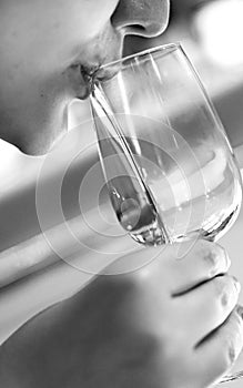 Young beautiful girl is drinking from the glass, black and white