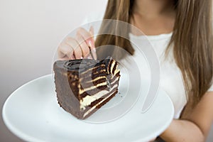 young beautiful girl eating cake, close-up, crop photo. woman's mouth eating a piece of cake