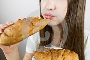 young beautiful girl eating a croissant, close-up, crop photo. female mouth eating croissant