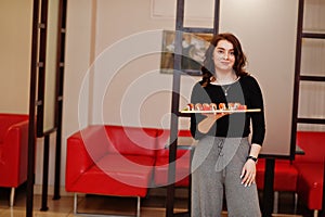 A young beautiful girl eating sushi on traditional Japanese restaurant