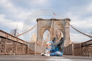 Young beautiful girl enjoying empty Brooklyn Bridge with a magical Manhattan island view