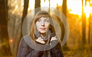 Young beautiful girl in evening autumn forest