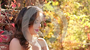 Young beautiful girl in an evening dress in an old abandoned Park in the autumn