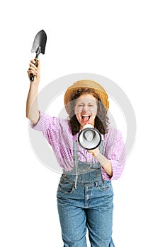 Young beautiful girl, female gardener in work uniform and hat shouting at megaphone isolated on white background