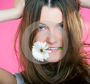 Young beautiful girl with flower in her mouth