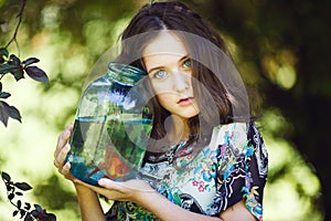 Young beautiful girl with gold fish