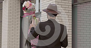 A young beautiful girl got angry and flogged her boyfriend with a bouquet of flowers