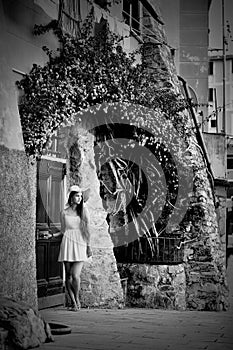 Young beautiful girl with hat and summer dress posing near vintage door