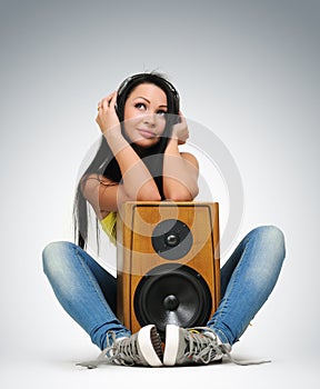 Young beautiful girl in headphones with speaker