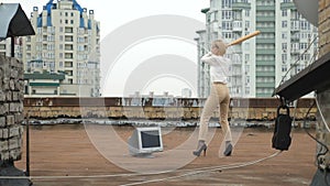 Young beautiful girl in high heels smashes the monitor with a bat. Bat, violence, hatred, anarchy, destruction, roof 60