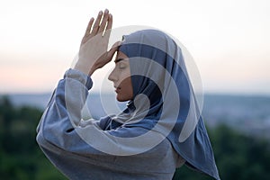 Young beautiful girl in a hijab prays and meditates