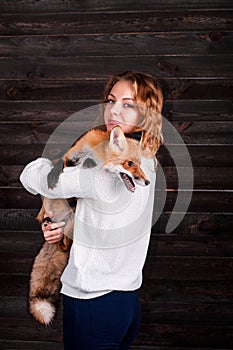 A young beautiful girl holding a wild fox animal that was traumatized by a man and rescued by her and now lives as before