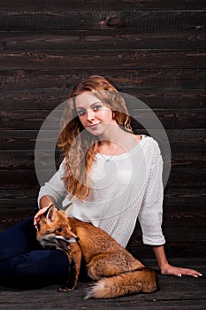 A young beautiful girl holding a wild fox animal that was traumatized by a man and rescued by her and now lives as before