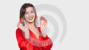 Young beautiful girl holding wooden hearts and smiling on Valentine`s day, copyspace