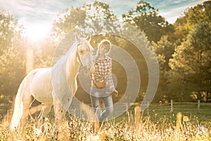 Young beautiful girl with a horse on the dry field