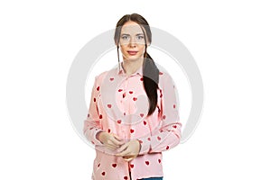 Young, beautiful girl iin a pink shirt with red hearts on a white background