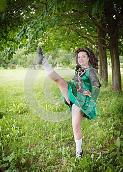 Young beautiful girl in irish dance dress dancing outdoor