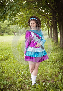 Young beautiful girl in irish dance dress posing outdoor