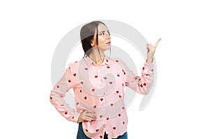 Young, beautiful girl isolated on a white background, points his fingers at the place for promo, offers or advertising