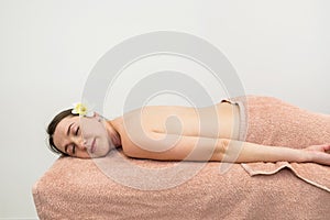 A young beautiful girl lies on a massage table in a spa salon before a procedure