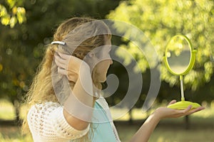 Young beautiful girl look into mirror in the park.Soft and blur conception.