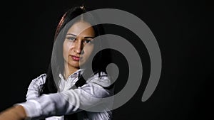 Young beautiful girl looking at camera brutally, holding bat over black background. slow motion