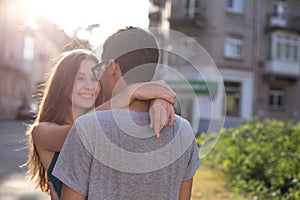 Young beautiful girl looks at the boy hugging his and smiling