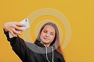 Young beautiful girl makes selfie on smartphone.